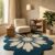 Blue and ivory daisy flower tufted rug with scalloped edge in a reading corner with a bouclé chair