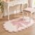 Blush pink bow tufted rug with scalloped ivory edge under a white vanity stool