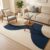 Navy blue and ivory abstract geometric tufted area rug in a living room with a beige sofa