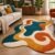 Retro wave tufted rug with rust, mustard and teal waves beside a cream sofa