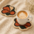 Abstract flower tufted coaster set of two in rust orange, forest green and cream with a latte mug